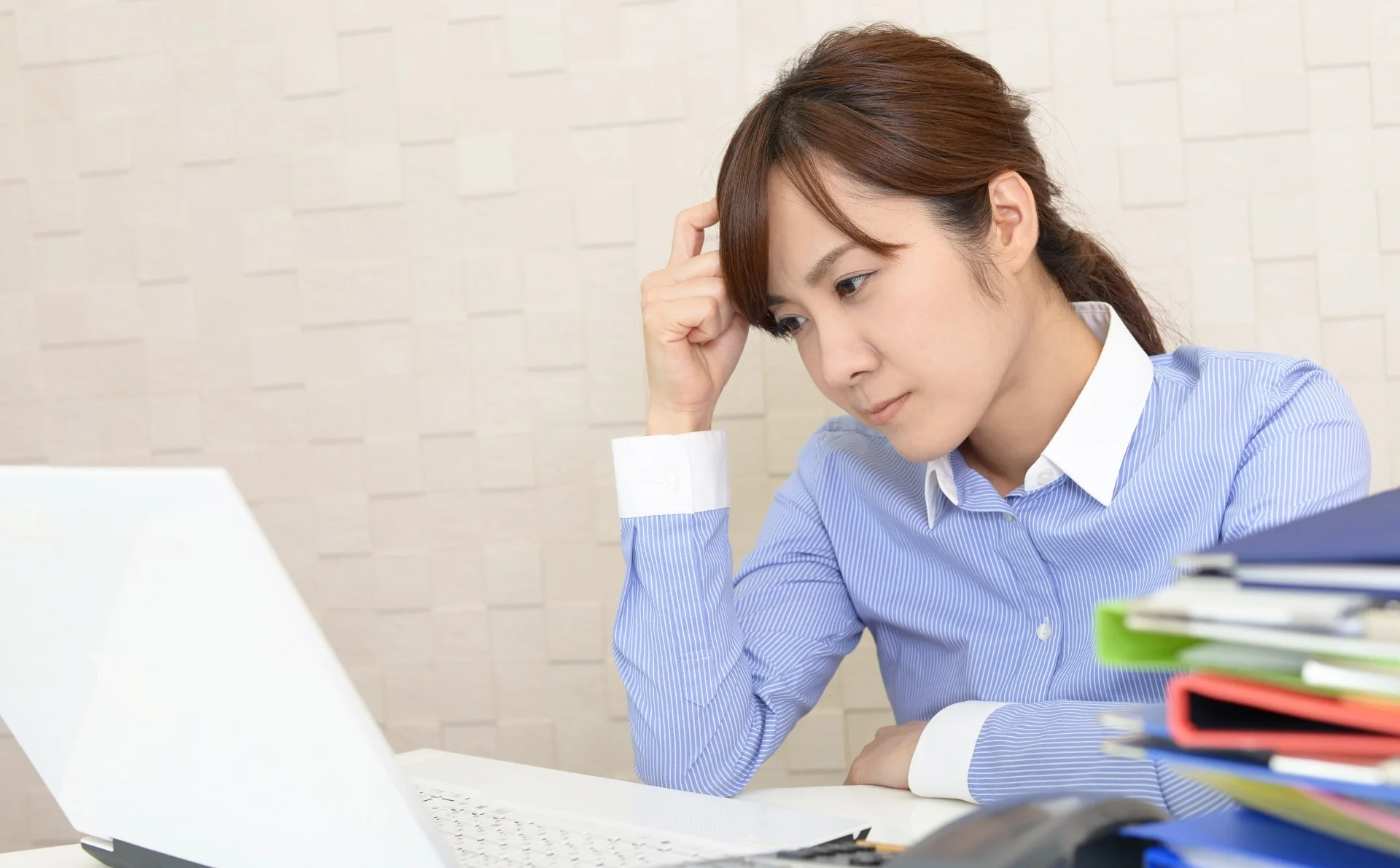 パソコンを前に悩む女性社員
