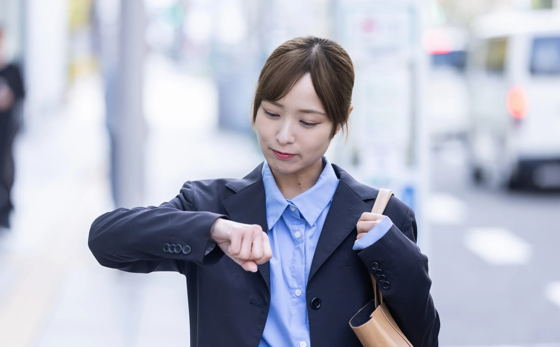 腕時計を見る女性会社員