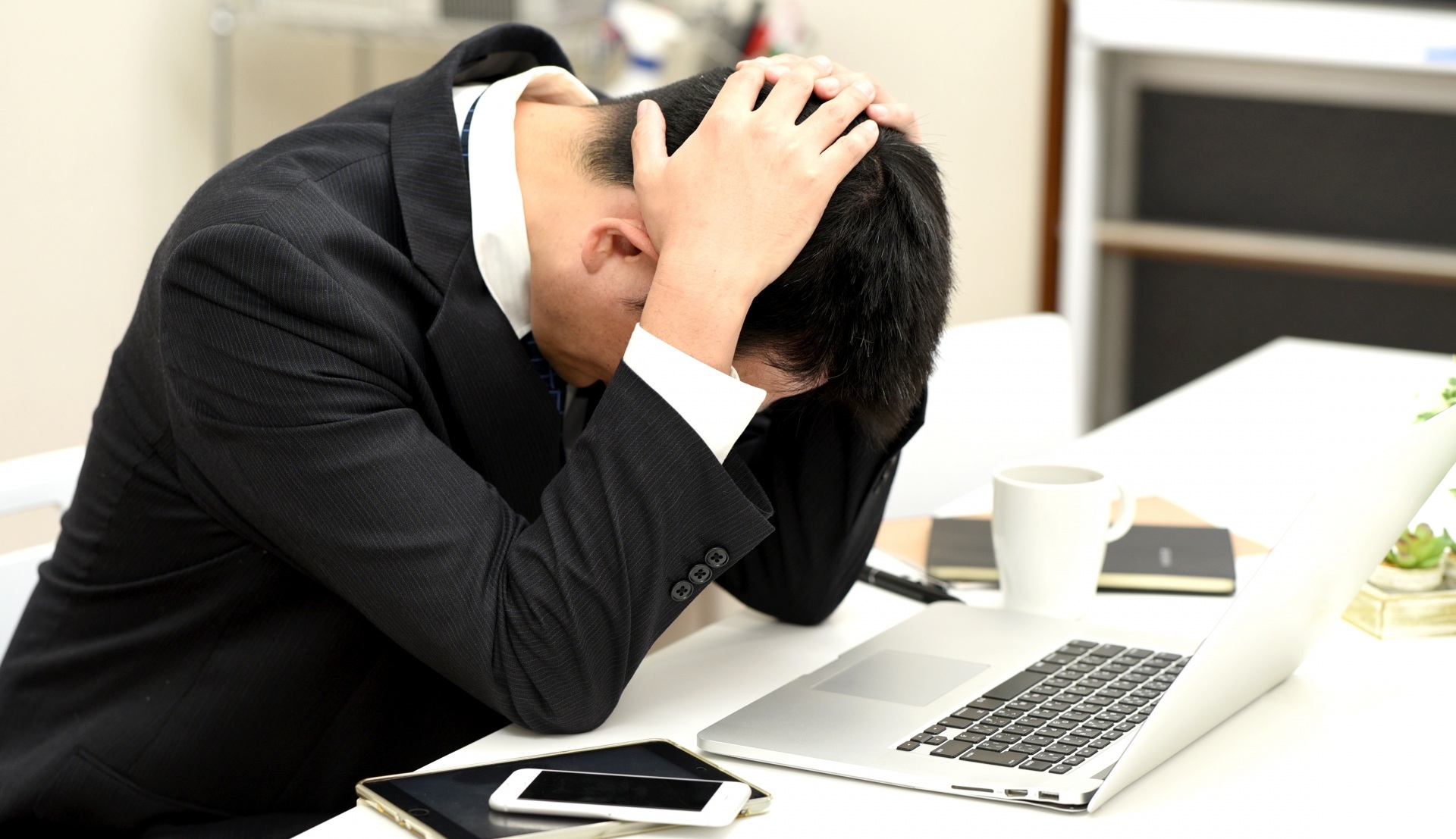 PCの前で頭を抱える男性社員