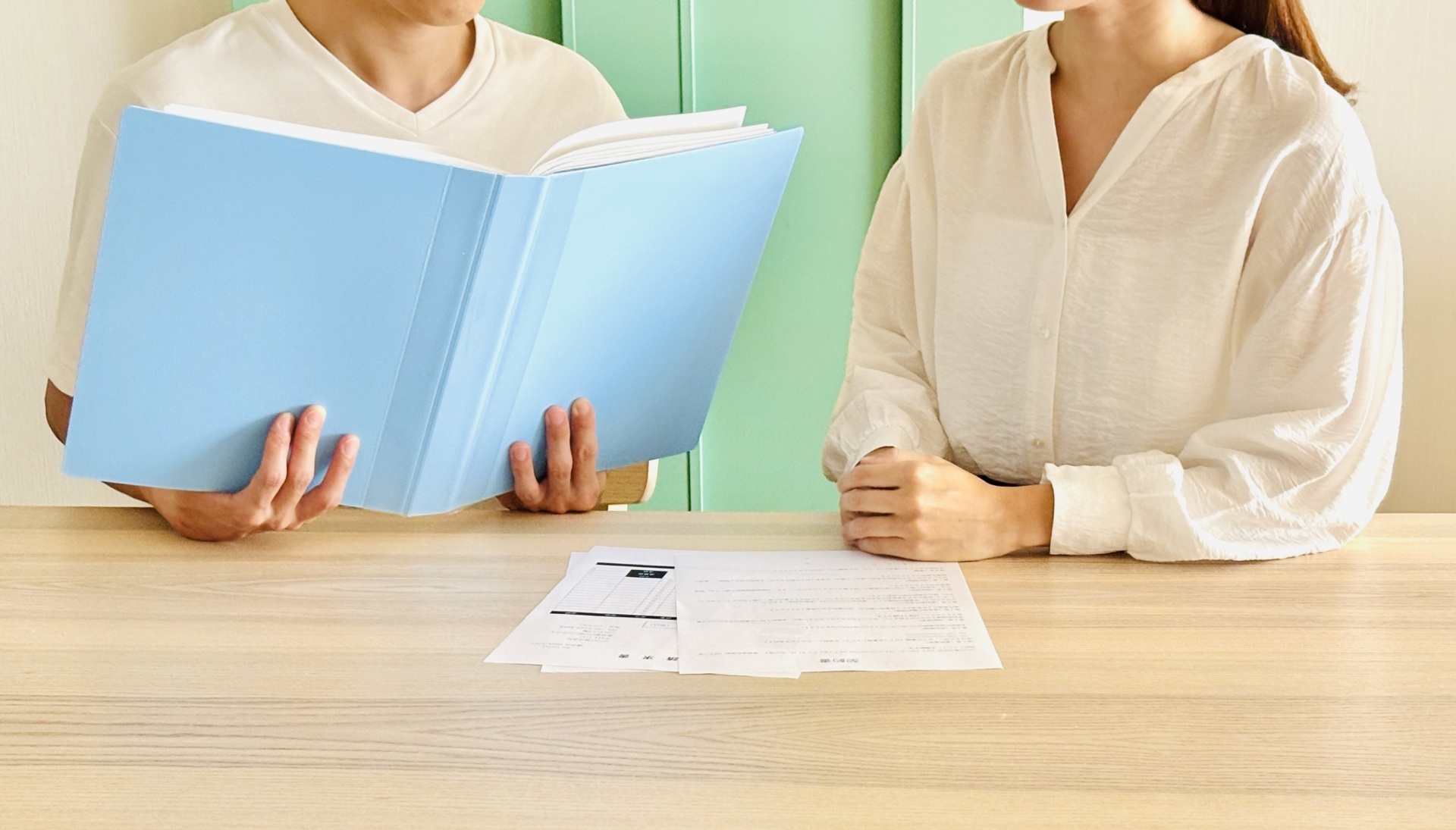 書類を見ながら話し合う人間