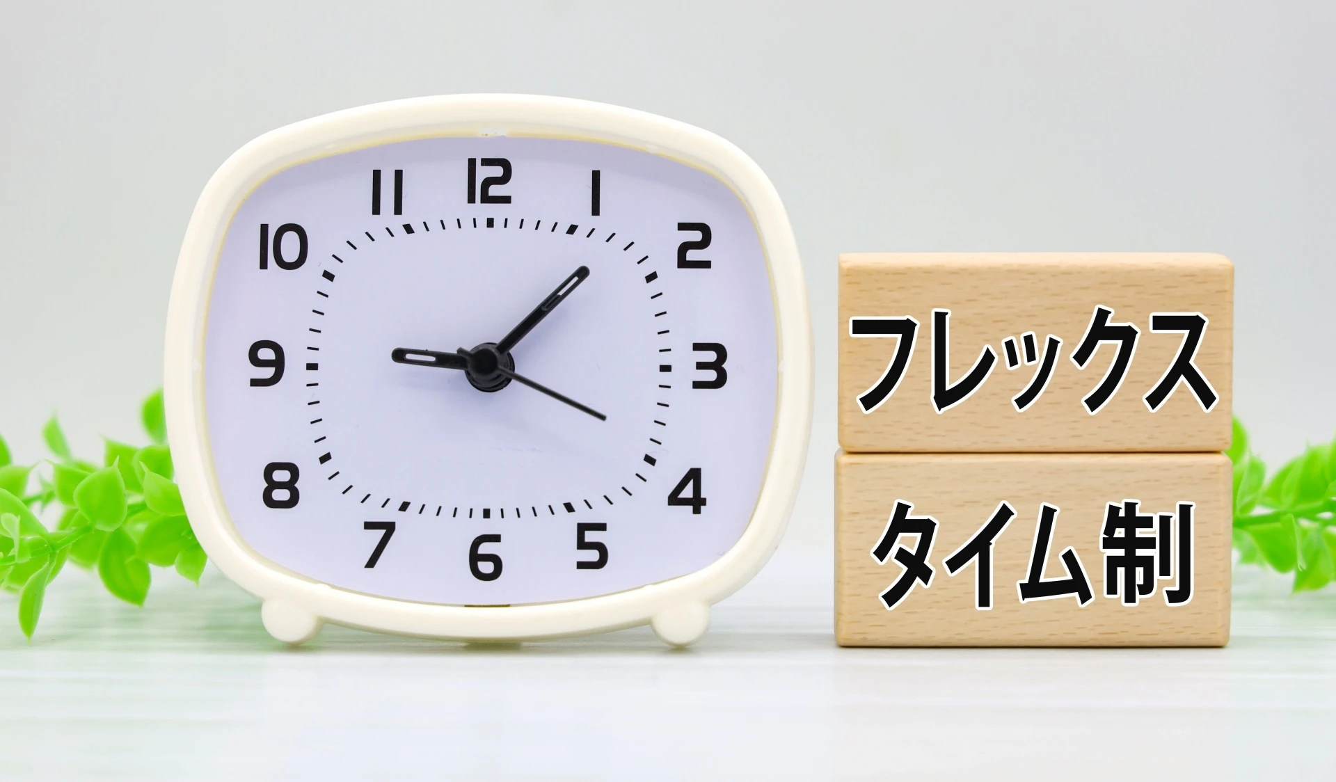 フレックスタイム制と書かれたブロックと目覚まし時計