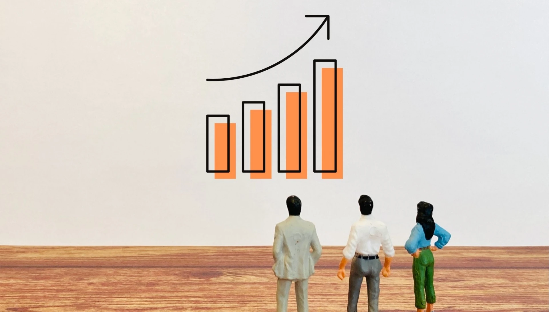右肩上がりのグラフを見るミニチュアの人間
