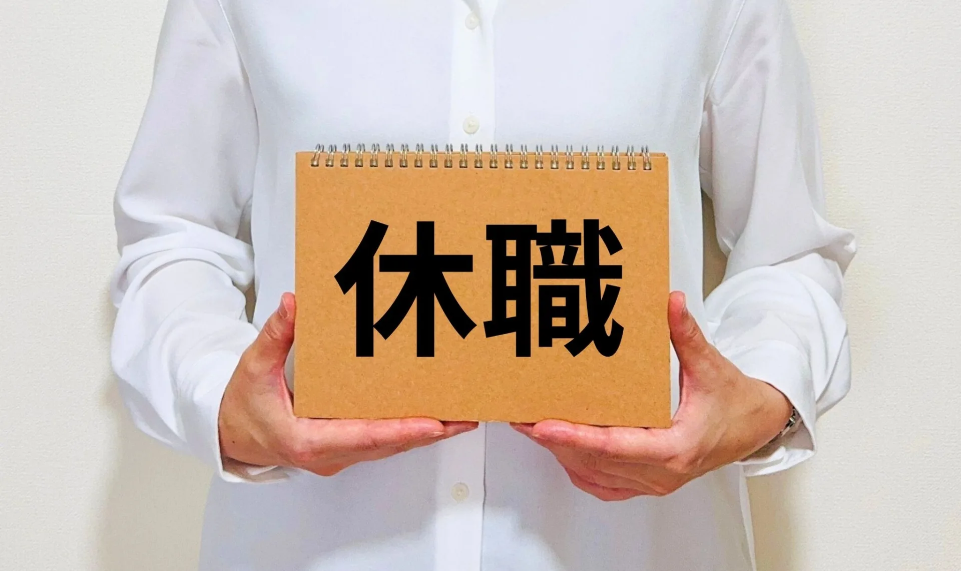 表紙に休職と書かれたノートを持った人間