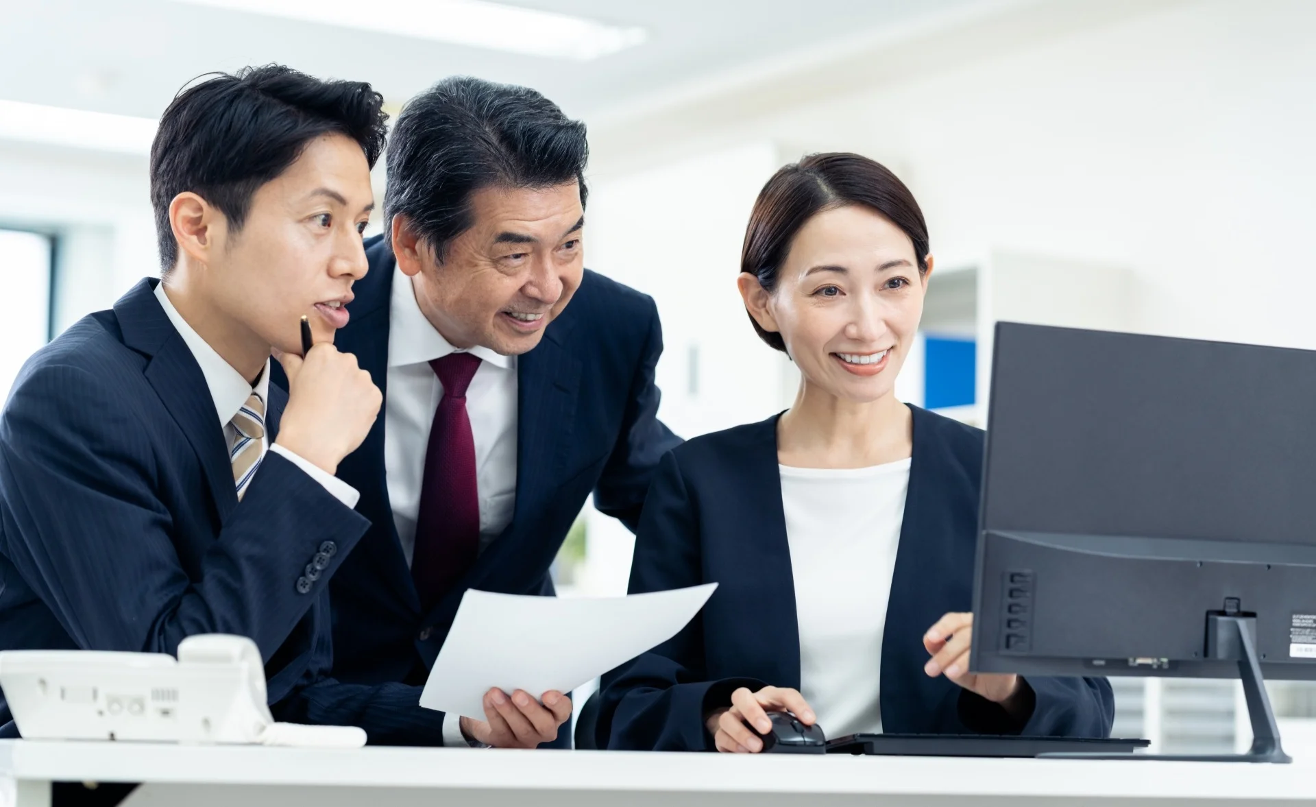 PCを見ながら談笑する社員