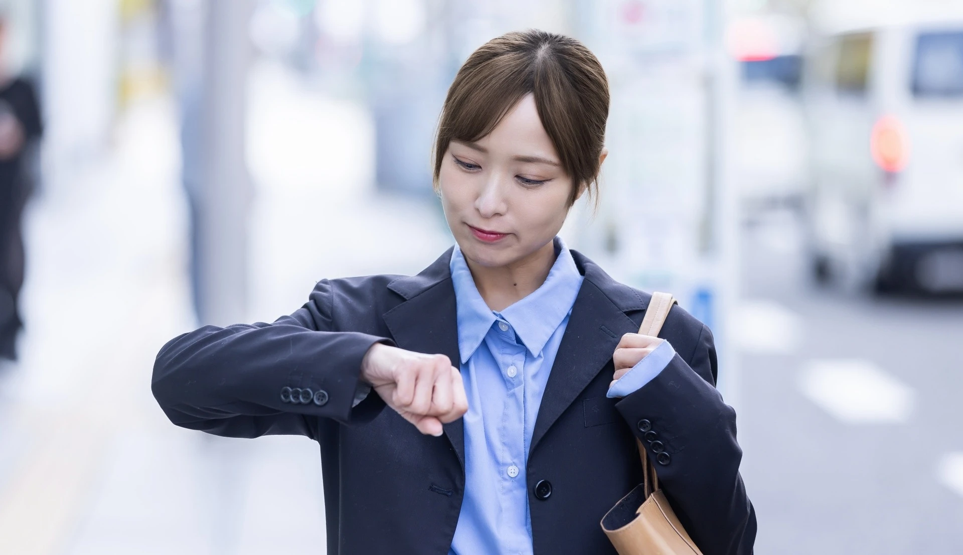 時計を見る女性会社員