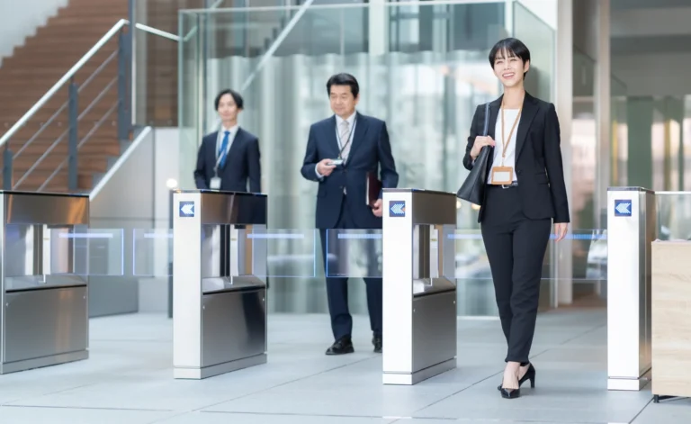 ビルのゲートを通る会社員３人