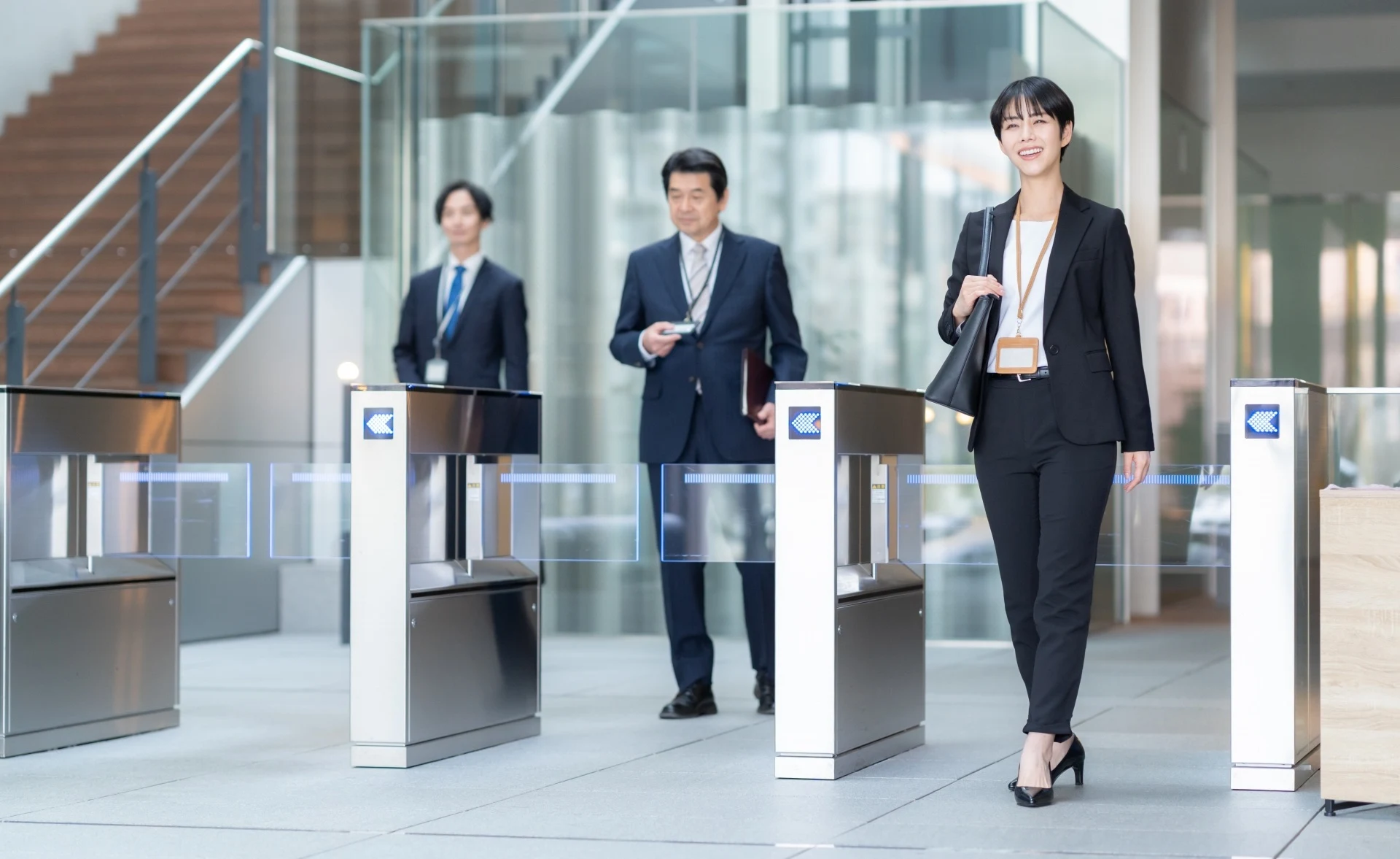 ビルのゲートを通る会社員３人