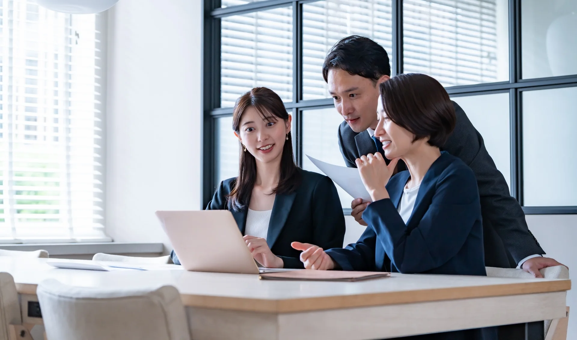 PCの前で談笑する社員