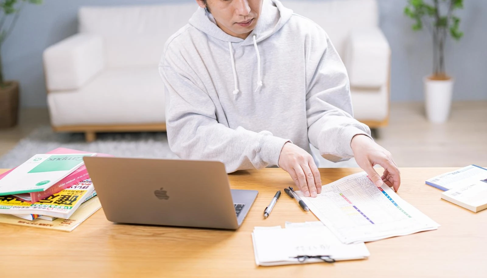 書類を並べてPCを見る男性