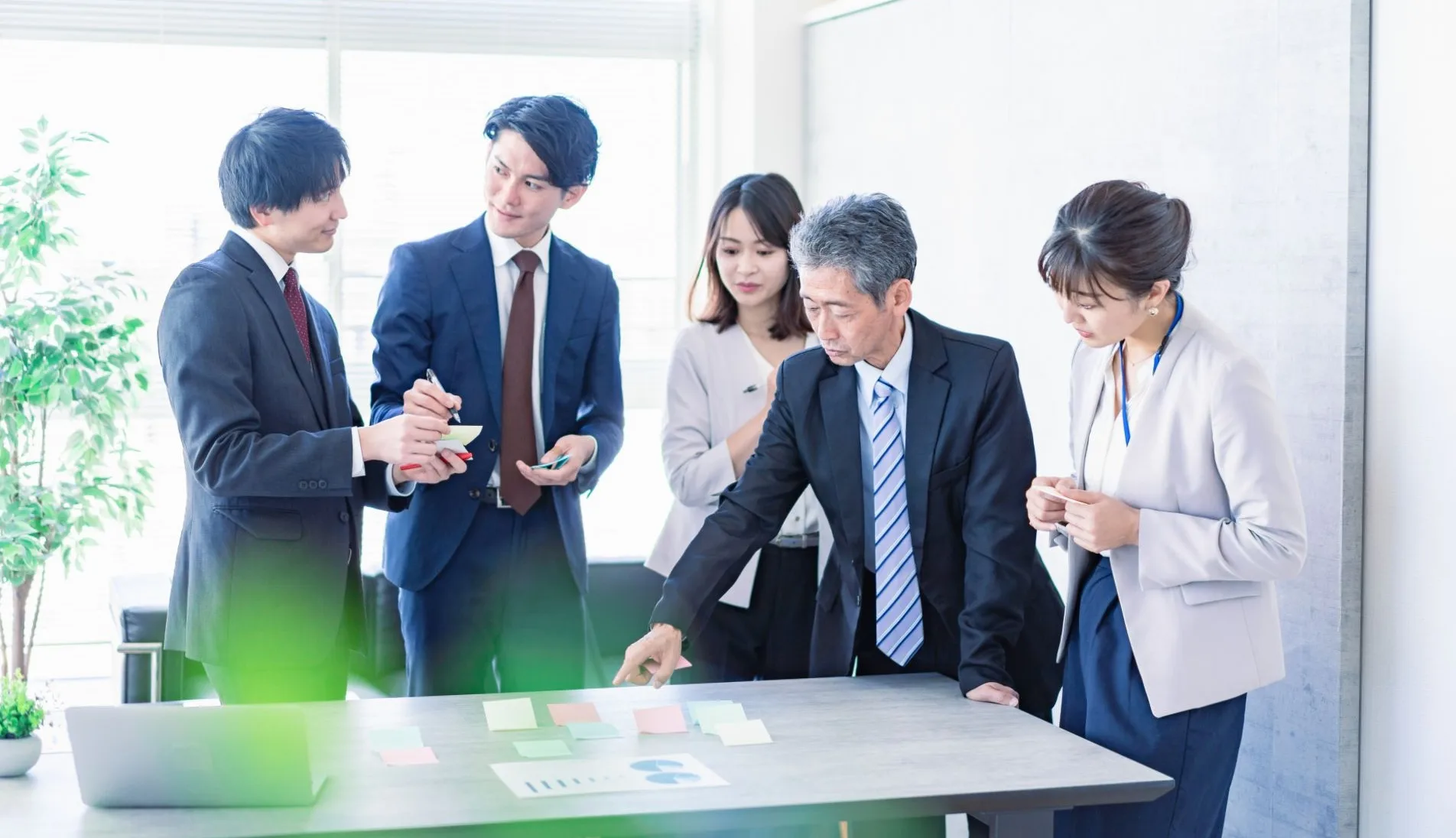 テーブルを囲んで会話する社員5名