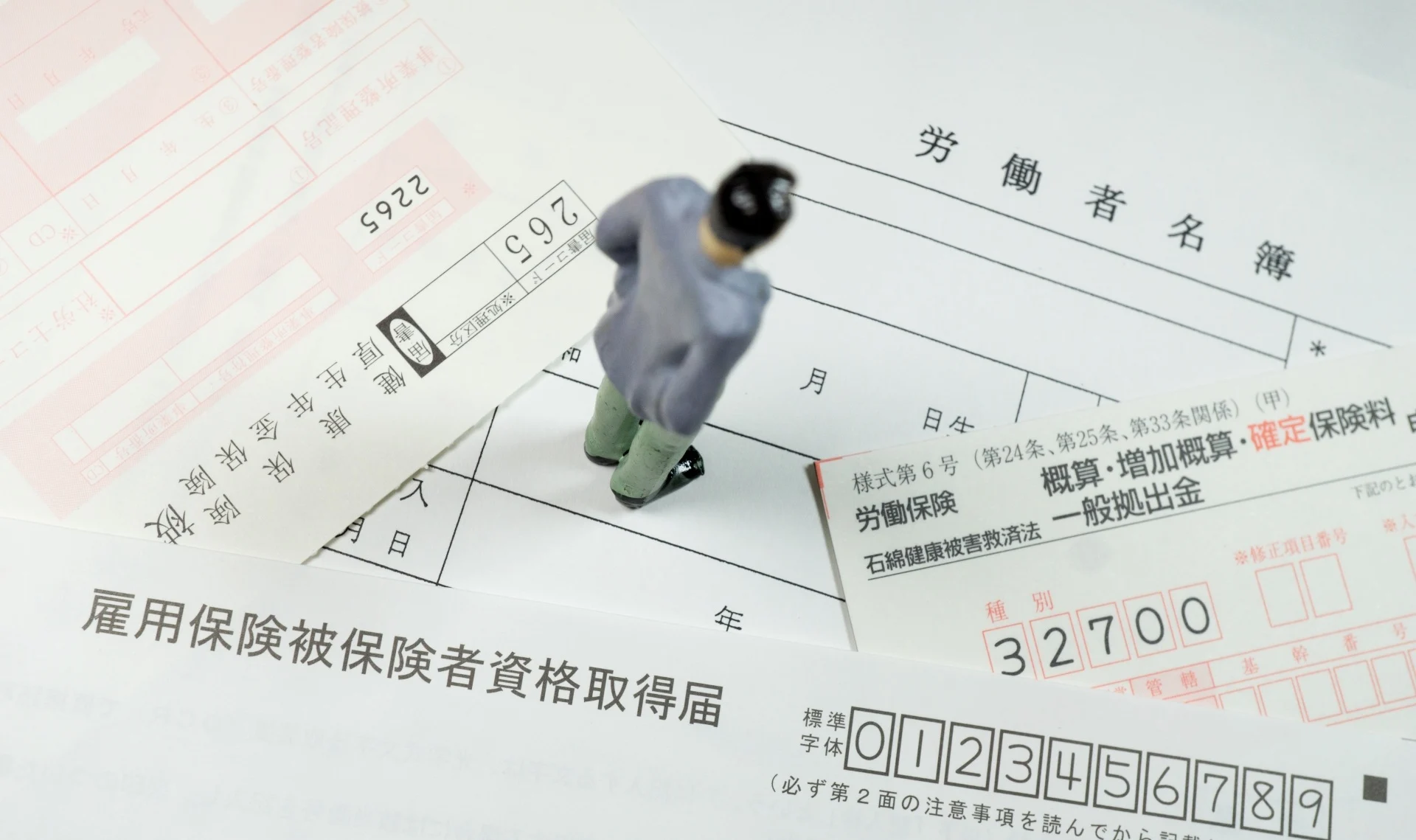 書類の上で立ってるミニチュアの人間