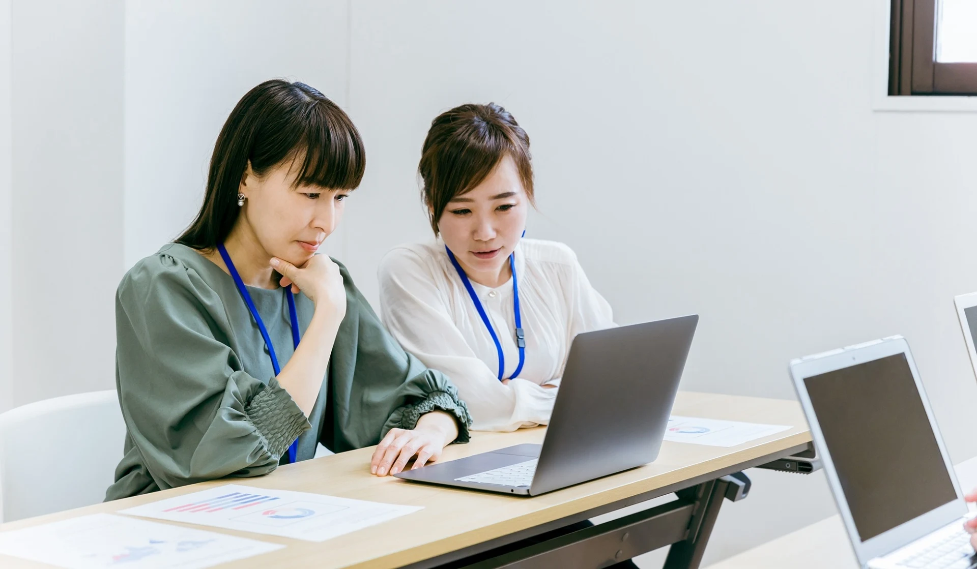 横並びでPCを見ながら会話する女性社員2名