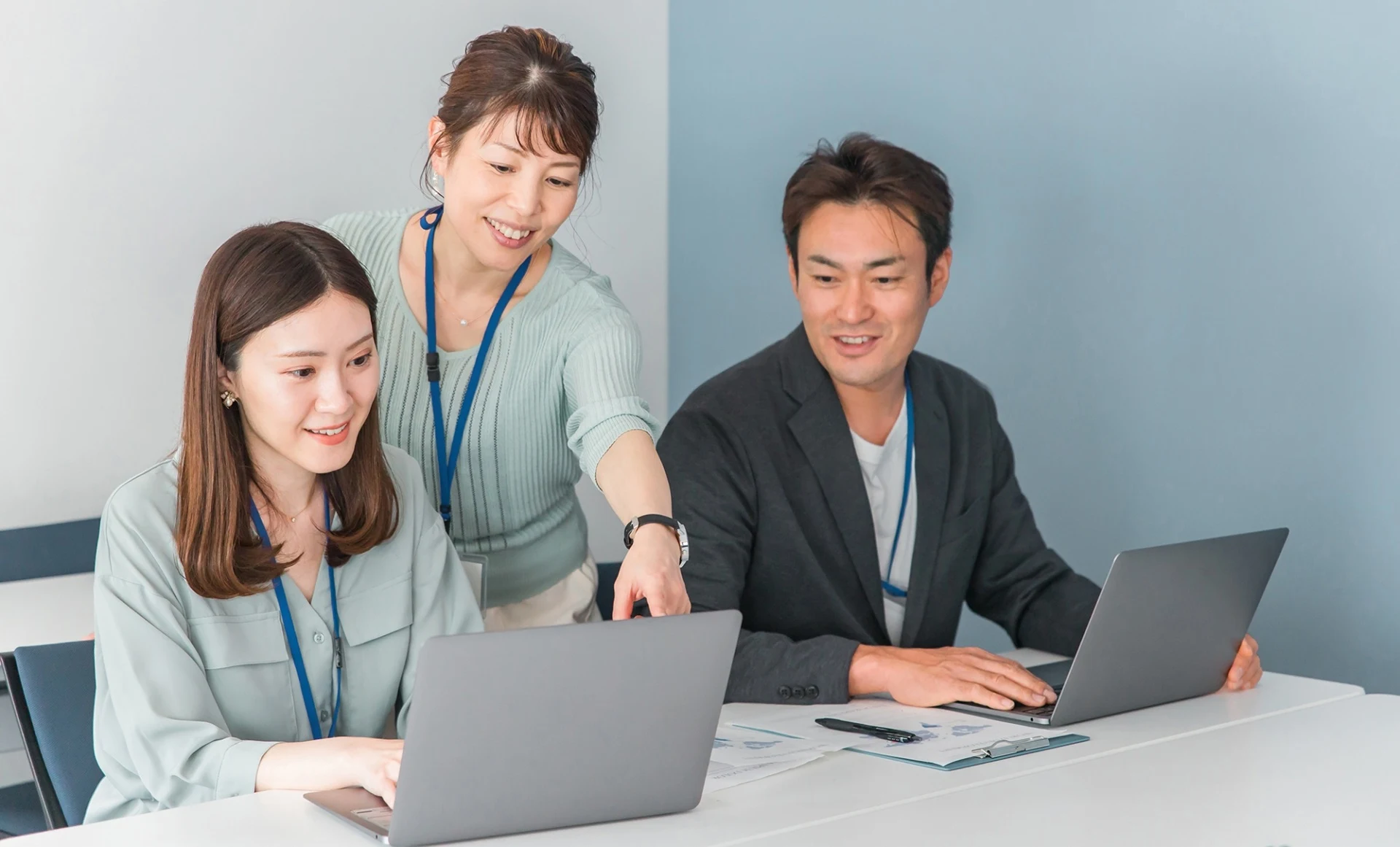 PCを見ながら談笑している社員たち