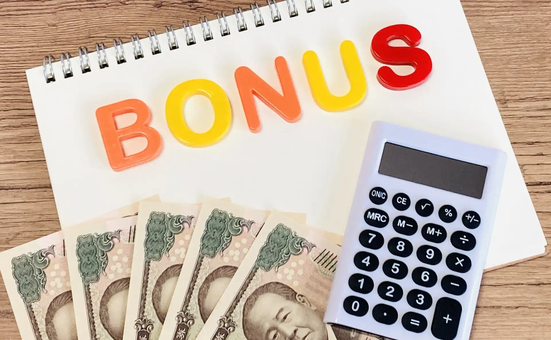 BONUSと書かれた紙とお金と電卓
