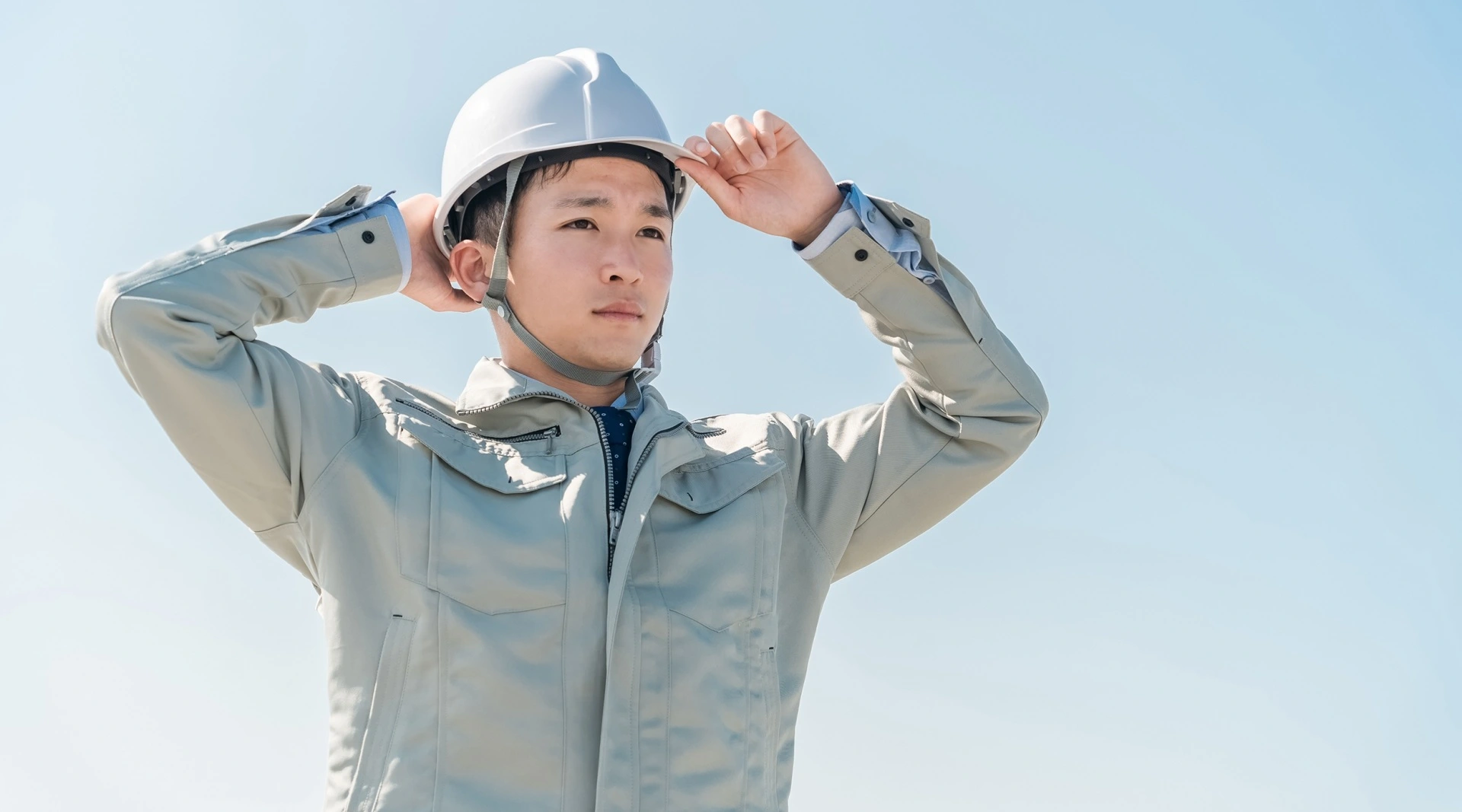 ヘルメットをかぶって作業服を着た男性