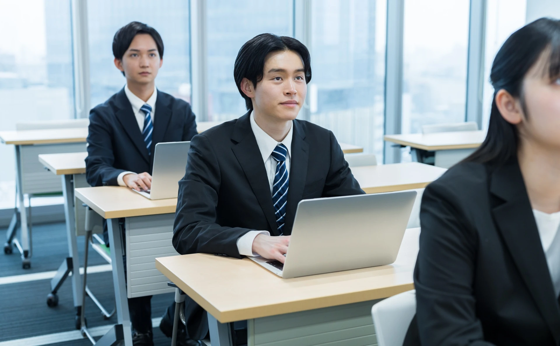 スーツを着て椅子に座っている男性社員