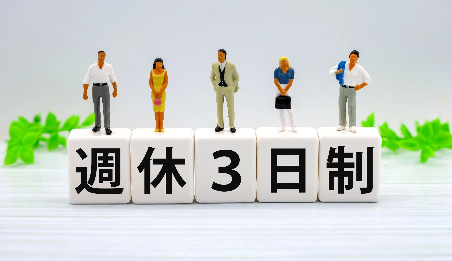 週休３日制とかかれたブロックとミニチュアの人形