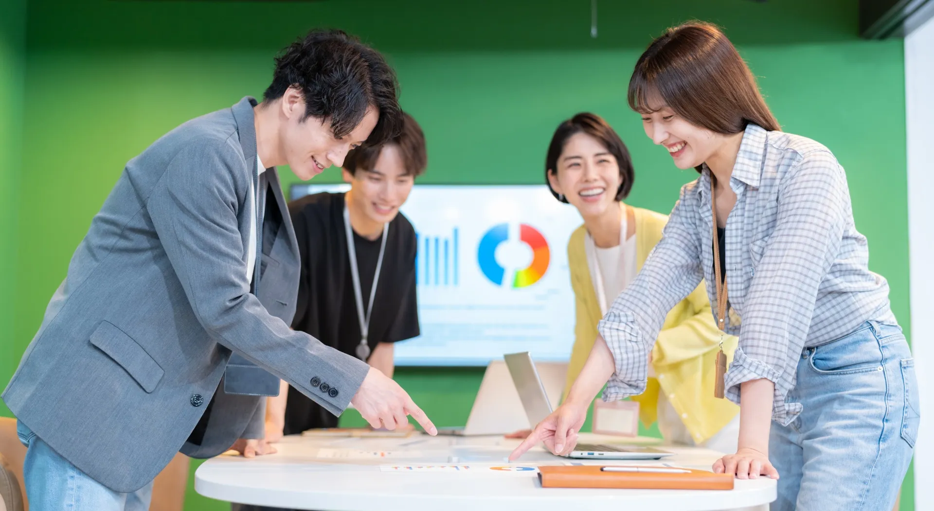 机を取り囲んでスキルマップについて会話する社員