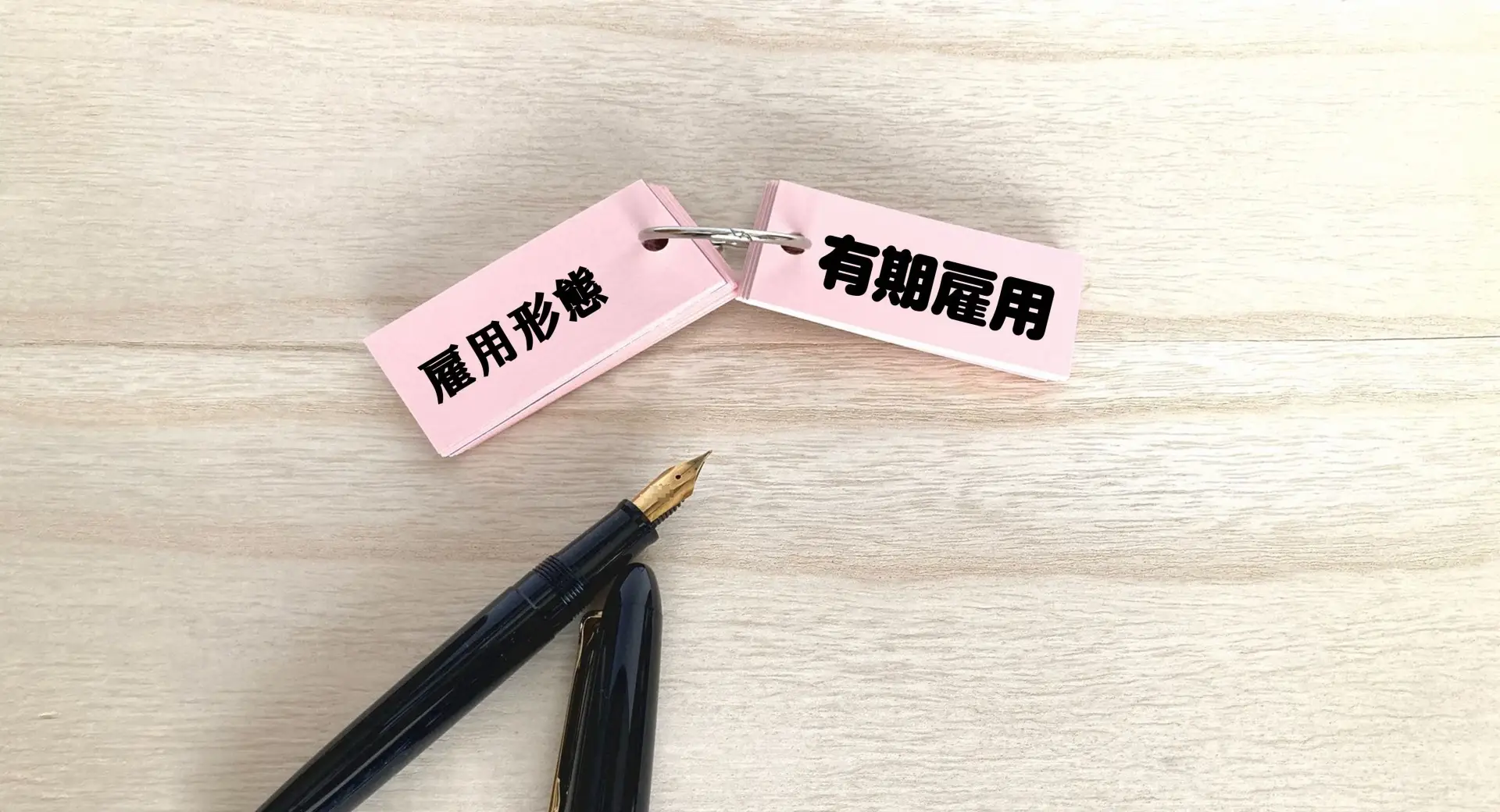 雇用形態と有期雇用が書かれた単語帳と万年筆